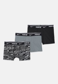 Tre paia di boxer Nike: uno con motivo a logo bianco e nero, uno grigio e uno nero uniforme. Tutti presentano una fascia in vita nera con logo bianco.