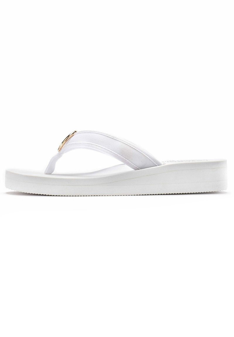 Witte flip-flop met een gevoerde zool, stoffen banden en een gouden ronde accent. Glad oppervlak met een vlak profiel en een gegroefde zool voor grip.