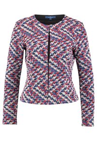 Veste multicolore avec un motif géométrique rouge, blanc et bleu. Elle a une coupe ajustée, des manches longues et une fermeture éclair à l'avant.