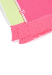 Kleurige strandhanddoek met groene en roze delen, met roze franjes langs één rand en witte stiksels. Bevat een label met een gestreept ontwerp.