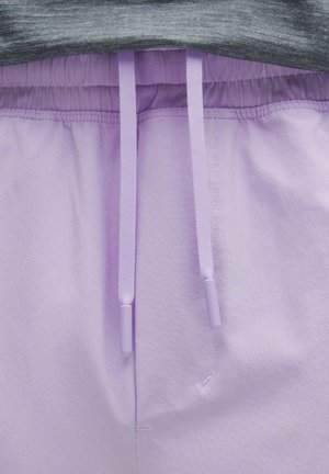 Hellblaue Sweatpants mit glatter Textur, elastischem Bund und zwei Kordeln mit Kunststoffspitzen. Graues Oberteil ist teilweise sichtbar.