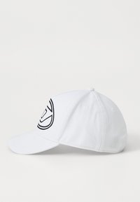 Fehér baseball sapka, elől fekete hímzett logóval, ívelt napellenzővel és szellőző lyukakkal az oldalon.
