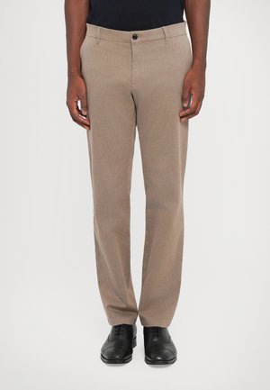 Tan dress pants with a smooth texture, straight leg design, and a single button closure. Paired with black leather shoes.