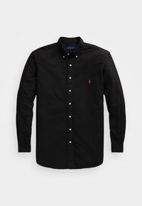 Svart skjorta med krage, långa ärmar, vita knappar och en liten röd logotyp på bröstet. Tillverkad av bomullstyg, slät yta.