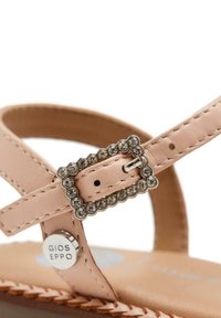 Cinghia di sandalo in pelle rosa con fibbia rettangolare abbellita da piccoli strass. Accompagnata da un accento metallico con marchio.