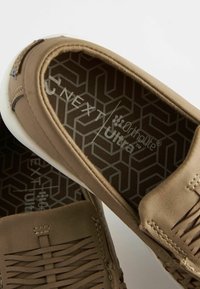 Lysebrune slip-on sko med en struktureret overdel, der har vævede detaljer og en mønstret Ortholite™ indersål. Hvid gummisål.