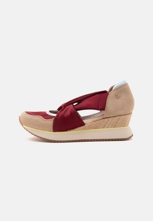 Chaussure compensée beige et bordeaux avec détails en tissu et en daim, côtés découpés, bout arrondi et semelle beige rainurée.
