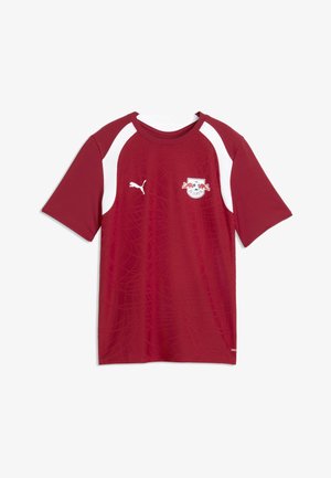 Rotes kurzärmeliges Sporttrikot mit weißen Schulterpanelen, Puma-Logo auf der rechten Brustseite und dem Wappen des Fußballclubs RB Leipzig auf der linken Brustseite.