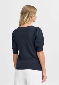 Pulover bleumarin cu mâneci scurte și puff, cu manșete și tiv cu un model în relief. Textură netedă, cu decolteu rotund și siluetă ajustată.
