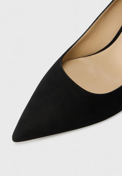 Black suede high-heeled shoe with a pointed toe and a low-cut vamp design. Smooth inner lining and minimal stitching detail.
