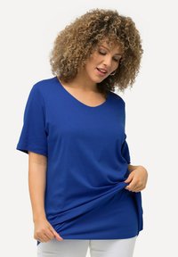 Blauwe kortermige V-hals T-shirt van zacht materiaal, valt losjes, met een relaxte pasvorm en een subtiele textuur, gecombineerd met witte broek.