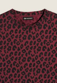 Camiseta de leopardo burdeos con cuello redondo, mangas cortas y una tela suave y texturizada. Etiqueta de la marca visible en el cuello.