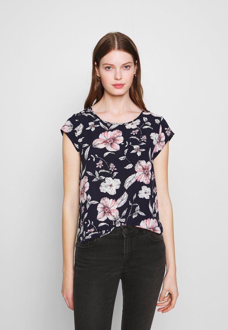 Top floral de manga curta com fundo azul-marinho, apresentando flores em rosa e branco. Tecido suave com decote redondo e corte solto.