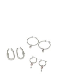 Ensemble de boucles d'oreilles en argent, comprenant une grande forme ovale, un charm en forme de serrure et un charm en forme de clé avec des accents roses. Texture métallique lisse sur l'ensemble.