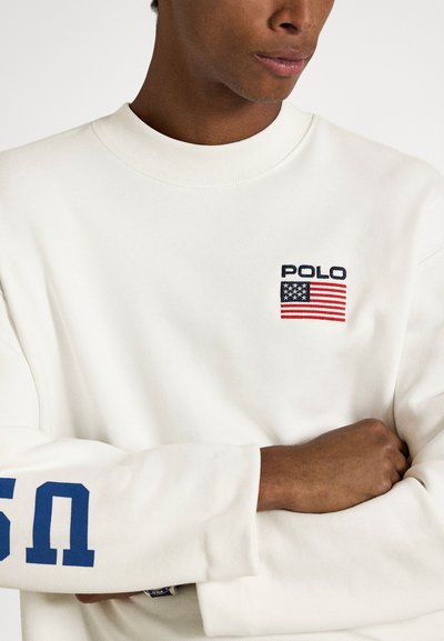 Sweatshirt branco de manga comprida com bordado "POLO" e bandeira americana. Estampa numérica azul na manga, gola e punhos canelados.