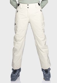 Helle beige Skihosen aus wasserabweisendem Material, mit bequemer Passform, mehreren Taschen und schwarzen Hardware-Akzenten.