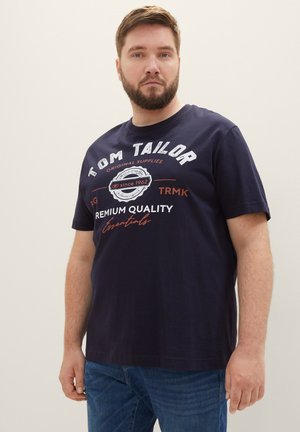 Marineblauwe katoenen t-shirt met korte mouwen, voorzien van witte en rode bedrukte tekst, ronde halslijn en een relaxte pasvorm.