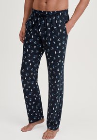 Marineblauwe pyjamabroek met een patroon van ski's en dennebomen, gemaakt van zachte stof, met een elastische tailleband en zijzakken.