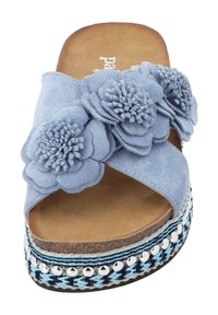 Light blue suede slide sandal featuring three stacked floral appliqués, a cushioned insole, and a braided sole with metallic studs.