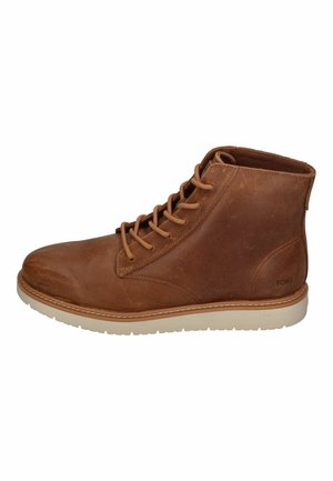 Brown leather ankle boots with lace-up closure, rubber sole, and stitched accents. Features a smooth texture and a minimalistic design.