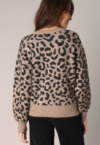 Leopardprint trui in beige en zwart, met een ontspannen pasvorm, lange mouwen, geribde manchetten en een ronde halslijn. Zachte textuur.