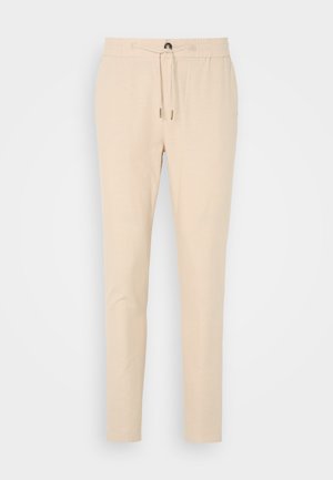 Bežne tapered hlače iz mehke tkanine, z elastičnim pasom in vrvico ter eno sprednjo žepom. Gladka tekstura in subtilen dizajn.
