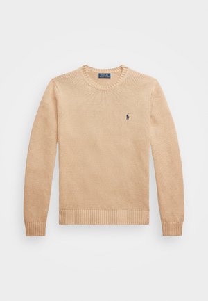 Beige knitted sweater with a crew neckline, ribbed cuffs and hem, featuring a small dark logo on the left chest. Soft texture.