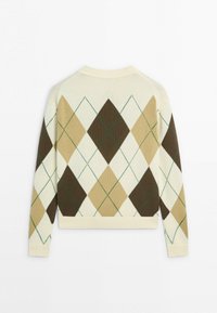 Pull en maille manches longues avec motif losanges argyle beige, marron et crème et lignes vertes cousues sur fond blanc.