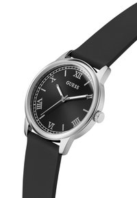 Czarny zegarek z srebrnymi akcentami, rzymskimi cyframi oraz silikonowym paskiem. Tarcza zegarka ma elegancki design z wskazówkami godzinową i minutową.