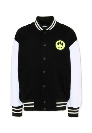 Sort og hvid varsityjakke med trykknapper, stribet krave og manchetter samt en gul lap med et potetryk og hugtænder på brystet.