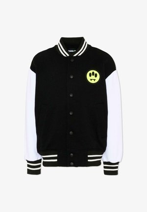 Sort og hvid varsityjakke med trykknapper, stribet krave og manchetter samt en gul lap med et potetryk og hugtænder på brystet.