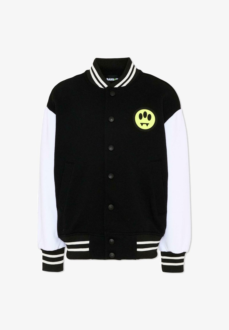 Giacca varsity bianca e nera con bottoni a pressione, colletto e polsini a righe, e una toppa gialla con un'impronta di zampa e zanne sul petto.