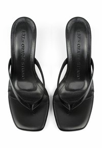 Czarne skórzane klapki z kwadratowym noskiem, cienkimi paskami i teksturowaną wkładką. Widoczne logo na wkładkach.