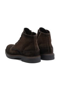 Brown suede ankle boots with a smooth finish, round toe, lace-up design, and a thick rubber sole. Features a zipper on one side.