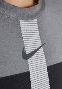 Graues Sportshirt mit Rundhalsausschnitt, horizontalen Streifen in kontrastierenden Farben und schwarzem Nike-Swoosh-Logo auf der Brust.