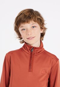 Rode lange mouwen pullover met een halve rits kraag, voorzien van een logo op de borst, een gladde textuur en ademend materiaal ideaal voor sportkleding.