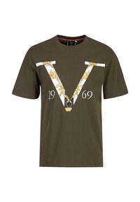 Olijfgroene katoenen T-shirt met korte mouwen, voorzien van een grote witte "V"-ontwerp met gouden bloemaccenten en het jaartal "1969" daaronder.