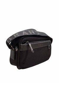 Sac à bandoulière noir à texture, avec poche zippée à l'avant, tirettes de fermeture éclair au logo, et bandoulière en tissu ajustable avec le texte "MARQUE".