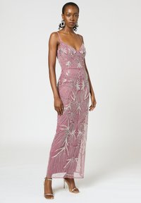 Abito lungo aderente di un rosa chiaro, arricchito con perline e paillettes argentate, con scollatura a V e spalline sottili.