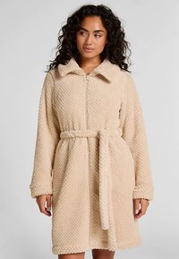 Beige, zachte badjas met rits, kraag en lange mouwen. Voorzien van een tailleband en een gestructureerde stof, geschikt voor comfort en warmte.
