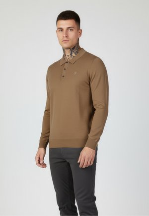 Brown long-sleeved polo top with a textured pattern, two-button placket, and logo detail on the chest, paired with dark trousers.