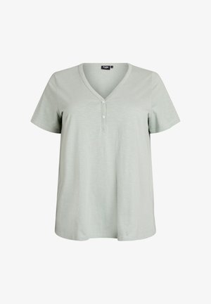 Camiseta gris claro de manga corta con escote en V y dos botones blancos en la tapeta frontal, mostrada sobre un fondo blanco.