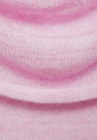 Mjukt, ljusrosa stickat tyg med en texturerad, något fluffig yta, vilket har en draperad design och lätta veck.