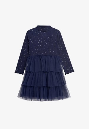 Granatowa sukienka z długimi rękawami, z ribbową górą ozdobioną złotymi kropeczkami i tiulowym, warstwowym dołem. Teksturowana tkanina kontrastuje z warstwami.