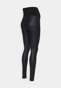 Leggings de maternidad negros con una cinturilla elástica alta, textura suave y forma ajustada, que cuentan con bolsillos traseros cosidos y un diseño elegante.