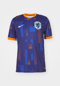 Maillot de football à manches courtes violet avec des accents orange. Présente des motifs de blocs irréguliers en bleu et orange, avec un écusson sur la poitrine.
