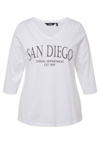 Weißes Baumwoll-langärmliges T-Shirt mit V-Ausschnitt. Mit dem Aufdruck "SAN DIEGO CASUAL DEPARTMENT EST. 1987" in Schwarz. Glatte Textur.