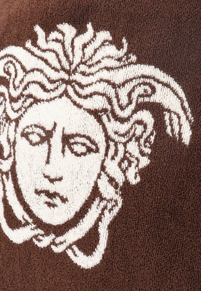 Σχέδιο κεφαλής Μέδουσας με ρέοντα μαλλιά σε λευκό χρώμα σε υφασμάτινο καφέ φόντο με υφή.