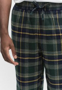 Herrars rutiga loungbyxor i grönt, marinblått och gult mönster. Tillverkade av mjukt material med elastisk midja och snöre.