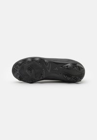 Zapatilla deportiva negra con una suela de goma moldeada y texturizada que presenta clavos angulares para un mejor agarre; diseño aerodinámico, con mínima visibilidad de la marca.